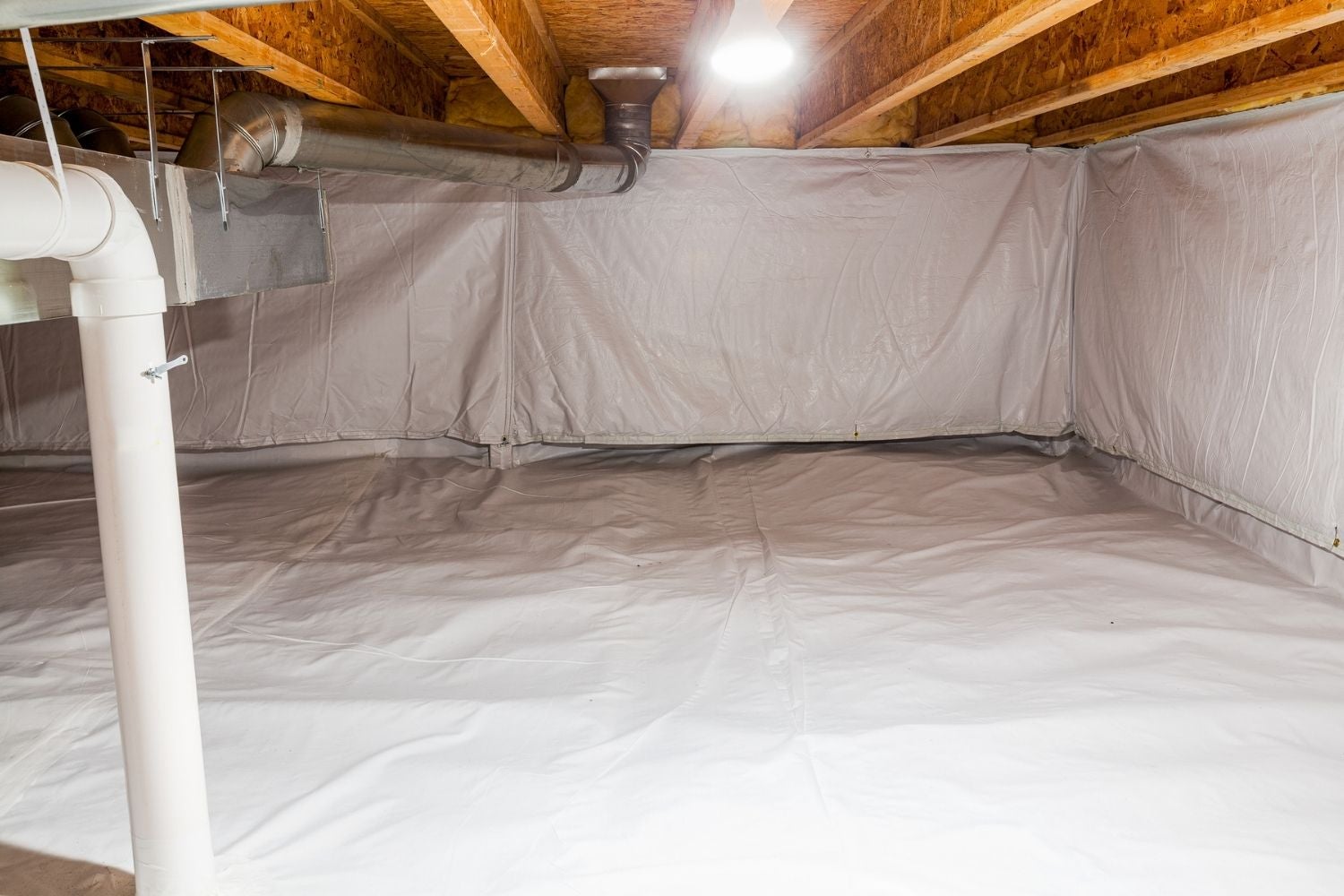 Crawl space encapsulation with white vapor barrier and ventilation system, illustrating indoor air quality solutions by EZ Breathe.