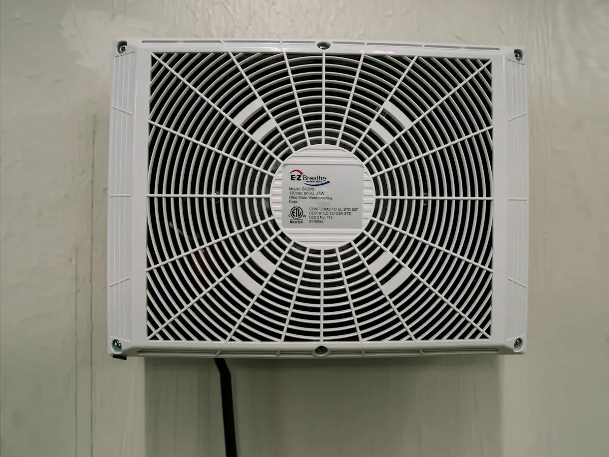 EZ Breathe ventilation system mounted on a wall, designed to improve indoor air quality by reducing allergens and moisture.